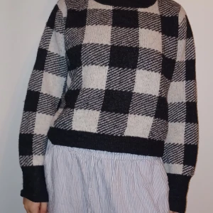 Svartvit rutig stickad tröja - Säljer en supermysig svartvit rutig stickad tröja. Perfekt för kyliga dagar med sin varma och sköna känsla. Tröjan har långa ärmar och en klassisk passform som funkar till allt. Ett måste i garderoben för höst och vinter!