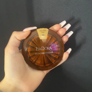 Bronzing Powder Golden Tan 46 från IsaDora - Säljer ett bronzing powder i nyansen Golden Tan 46 från IsaDora. Perfekt för att ge ansiktet en solkysst look. Kompakt förpackning med spegel, lätt att ta med i väskan. Använd för att framhäva kindbenen eller ge hela ansiktet en varm ton.