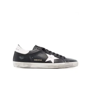 Svarta sneakers från Golden Goose - Säljer ett par svarta Golden Goose sneakers i bra skick. De har en vit stjärna på sidan och vit häl med text. Skorna har en cool, sliten look och är perfekta för vardagsbruk. Storlek 40. Använda 2 gånger säljer då de kommer till användning, kan gå ner i pris vid snabb affär.