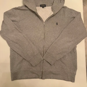 Grå Ralph Lauren Zip-up  - Säljer denna ralph lauren koftan som är perfekt för hösten! 🍂 Den har inga defekter och är nästan i ny skick. 💫  Den är XL i Ralph Laurens barnstorlekar, och det är S i herrstorlekar. 😇  Skriv om fler bilder eller frågor! 😄  Pris kan diskuteras 🤩