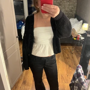 Svart stickad kofta - Säljer en mysig svart stickad kofta med knappar framtill. Perfekt för höst eller på sommarn när man vill dra över sig något om det blåser lite. Den är både varm och stilren. Koftan har långa ärmar och en normal kroppad form.