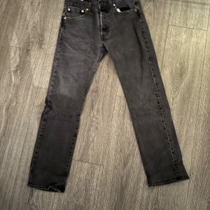 Svarta jeans från Levi's - Säljer ett par svarta Levi's jeans i bra skick. De har en klassisk femficksdesign med knapp och dragkedja framtill. Perfekta för både vardag och fest! 🖤
