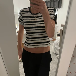 Randig ribbad croppad topp - Säljer en superfin randig topp i svart och vit. Den är ribbad och croppad, perfekt för en avslappnad stil. Toppen har korta ärmar och är i mycket bra skick. Passar perfekt till vardagen med jeans eller kostymbyxor!