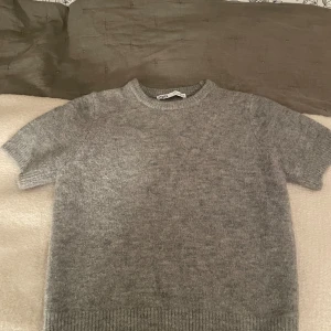 Grå stickad tröja från Zara - Mysig grå stickad tröja från Zara i storlek S. Perfekt för kyliga dagar med sin mjuka och varma känsla. Tröjan har en klassisk design med ribbade kanter vid ärmslut och nederkant. Pris kan diskuteras och den passar även mig som vanligtvis har strl xs men såklart även dom som har s!❤️