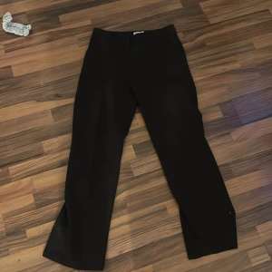 Svarta byxor från Madlady - Säljer ett par svarta byxor från Madlady i storlek EU38/Short. De har en klassisk och stilren design, perfekt för både vardag och fest. Byxorna är i bra skick och har en normal passform.