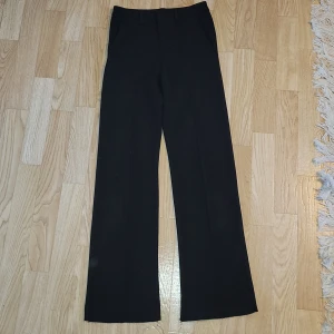Svarta byxor från Kappahl - Säljer ett par svarta byxor från Kappahl i storlek 158. Dem är nerlagda 1 cm. De har en klassisk design med en rak passform och sydda pressveck. Perfekta för festliga tillfällen, rekommenderar inte att ha på en varm eller kall dag, du väljer själv. Materialet känns mjukt och bekvämt mot huden. Pris kan diskuteras 