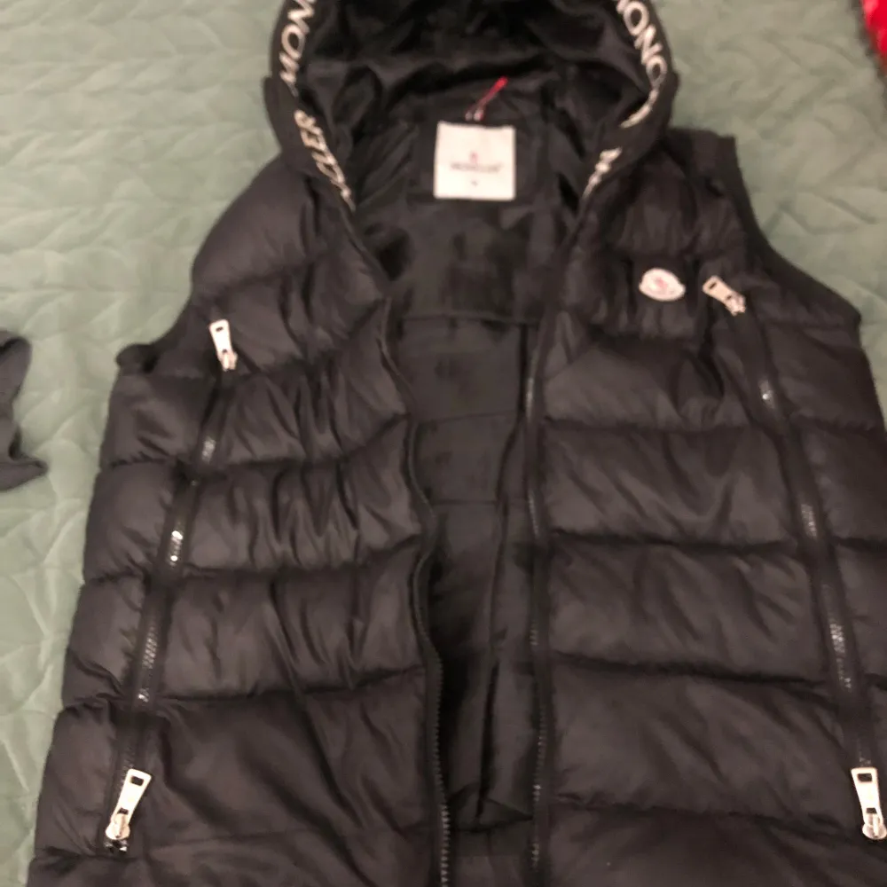 Säljer en snygg svart jacka från Moncler i storlek M. Perfekt för kyligare dagar med sin stilrena design och högkvalitativa material. Jackan har Monclers ikoniska logga broderad på bröstet. Passar både till vardags och festliga tillfällen.. Jackor.