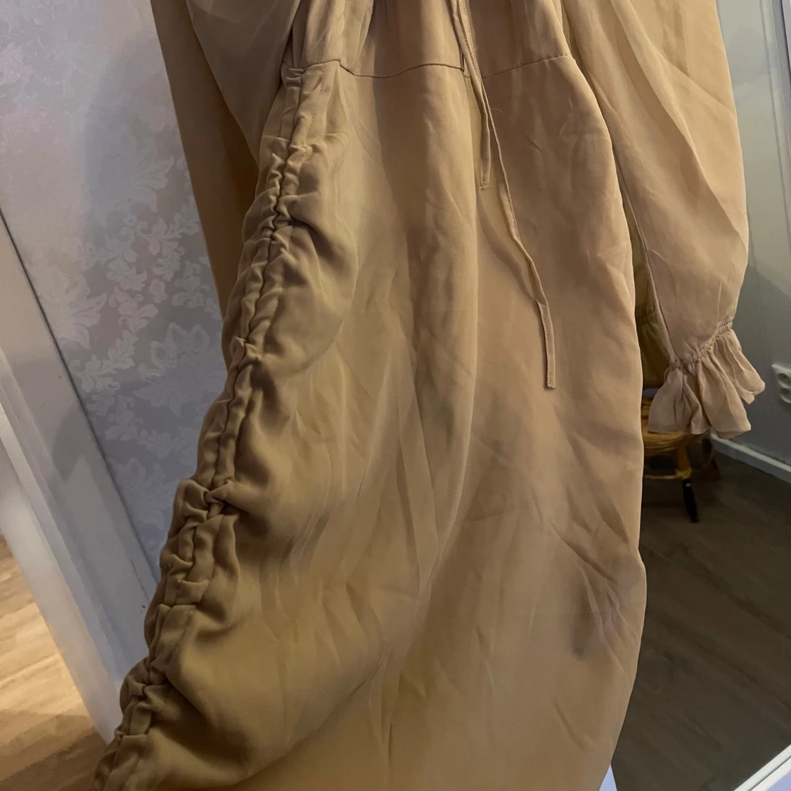 Beige klänning med volangdetaljer