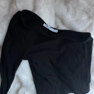 Svart oneshoulder topp från NA-KD - Snygg svart oneshoulder topp från NA-KD i ribbat material. Perfekt för en utekväll eller fest. Säljer pga för liten för mig.💞 