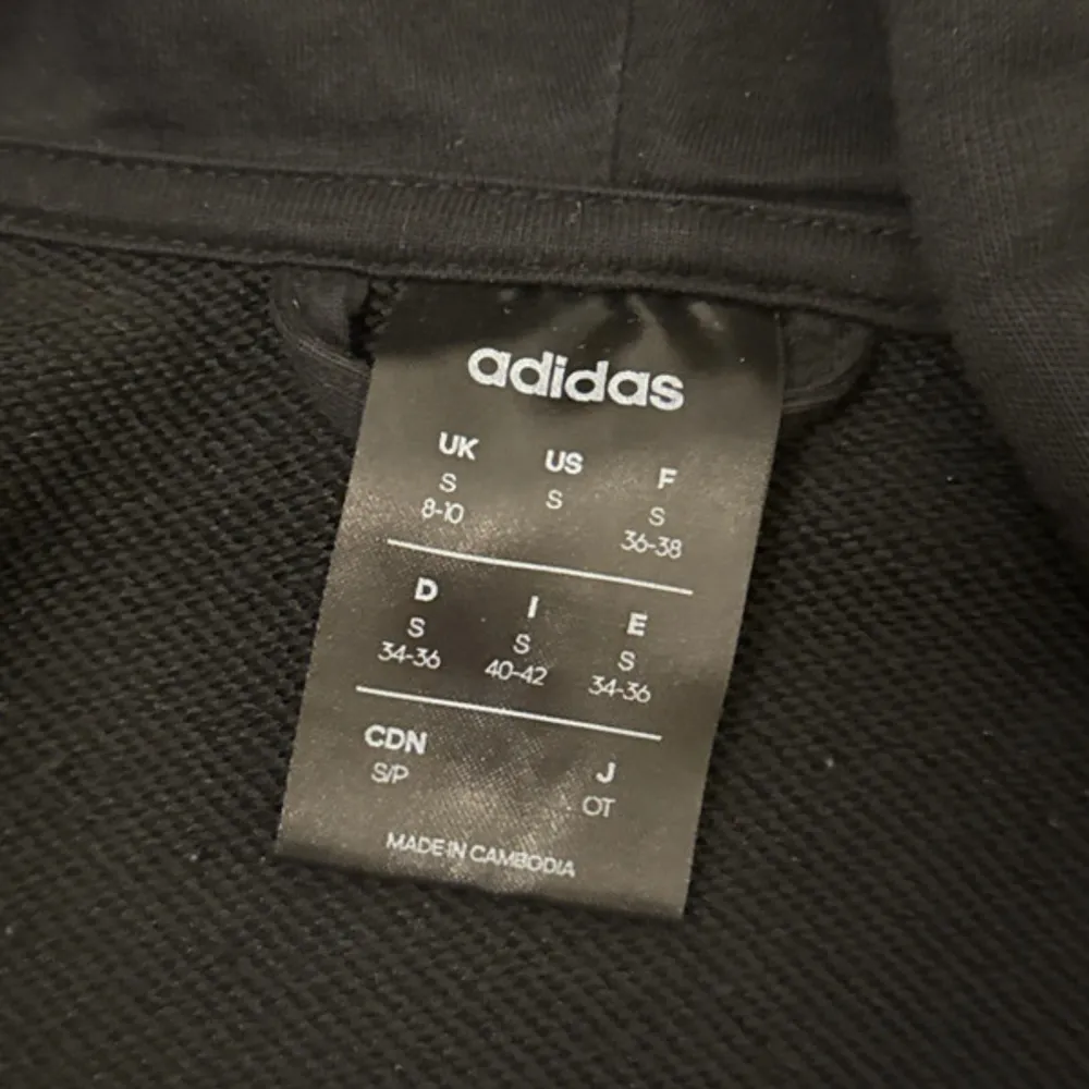 Säljer en svart hoodie från Adidas i mycket bra skick. Den har de klassiska tre vita ränderna längs ärmarna och en dragkedja framtill. Perfekt för både träning och vardag. Storlek S, men passar även som en lite loose fit . Grymt skön och stilren!. Tröjor & Koftor.