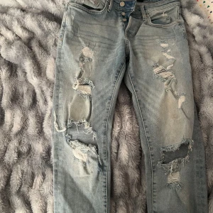 Ljusa skinny jeans med slitningar - Säljer ett par ljusa skinny jeans från 8 Denim i storlek 29. De har coola slitningar på framsidan och en knappgylf. Perfekta för en avslappnad stil med lite edge! 🕶️