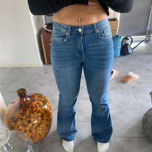 Säljer ett par snygga blå bootcut jeans i bra skick. De är högmidjade och har en klassisk femficksdesign med dragkedja och knapp. Perfekta för både vardag och fest! 🦋