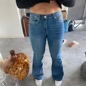 Blå bootcut jeans - Säljer ett par snygga blå bootcut jeans i bra skick. De är högmidjade och har en klassisk femficksdesign med dragkedja och knapp. Perfekta för både vardag och fest! 🦋