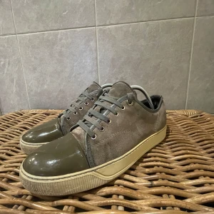 Lanvin skor  - Säljer ett par gröna/Grå skor från Lanvin i bra skick. Skorna har en snygg kombination av skinn och mocka med en glansig tå och snörning. Sulan är i en ljusare beige färg som ger en cool kontrast. Perfekta för både vardag och fest! Skriv för fler frågor och bilder. Pris kan diskuteras vid snabb affär!! Skickas inom en dag🚚📦