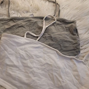 Två linnen från Divided - Säljer två basic linnen från Divided i storlek M. Ett är grått och det andra är vitt. Perfekta för sommaren eller som lager under andra plagg. De är i bra skick och gjorda av mjuk bomull. Passar till både vardag och fest!