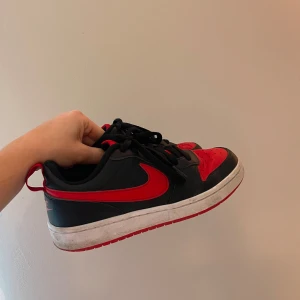  Svarta/röda Nike sneakers - Säljer ett par snygga Nike sneakers i svart och rött. De har en klassisk design med snörning och en bekväm passform. Skriv för frågor! 💞