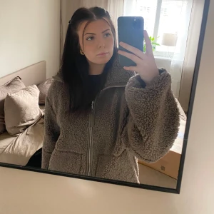 Mysig teddyjacka i beige - Säljer en supermysig teddyjacka i beige. Den är helt slutsåld på H&M hemsida. Sitter oversize och är i en strl M. Köpare står för frakt.