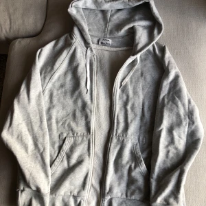 Grå hoodie från Acne Studios - Säljer en stilren grå hoodie från Acne Studios i bra skick. Den har en dragkedja framtill och en justerbar huva med snören. Perfekt för både höst och vår, och passar till de flesta outfits. Superbekväm och enkel att matcha! Tänkt som en S för herr som ska vara oversize, men funkar då också för M som jag.