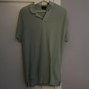 Grön pikétröja från Massimo dutti - Snygg grön pikétröja från Massimo dutti med klassisk krage och korta ärmar. Perfekt för en avslappnad stil. Ett väldigt bra skick på tröjan då jag inte har använt den så mycket. Skick 9/10