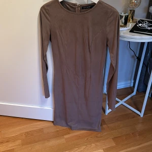 Brun klänning från Hickap - Säljer denna fina bruna klänning som är sparsamt använd, den är ifrån hickap och är i skönt Mocca material. 