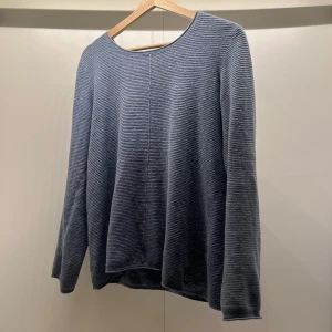 Grå ribbad tröja - Säljer en stilren grå/blå ribbad tröja med rund halsringning. Tröjan har långa ärmar och en avslappnad passform, perfekt för kyligare dagar. Enkelt och tidlöst plagg som passar till det mesta.