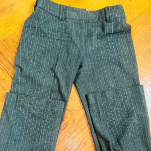 Grå randiga byxor från s.Oliver  - Snygga grå byxor med diskreta ränder från s.Oliver .material ull . De har en klassisk design med bälteshällor .