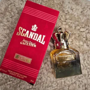 Scandal Absolu från Jean Paul Gaultier - Säljer en lyxig parfym, Scandal Absolu, från Jean Paul Gaultier. Flaskan har en unik design med en krona som lock och en elegant guldton. Förpackningen är röd med guldtext och ger en känsla av exklusivitet. Perfekt för den som vill sticka ut med en djärv doft.