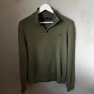 Polo Ralph Lauren - Tja mannen! Säljdr en snygg olivgrön kofta från Polo Ralph Lauren med ribbad krage och knappar. Perfekt för kyligare dagar med sin stilrena design och diskreta logga på bröstet.