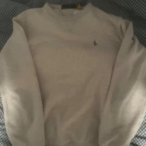 Beige sweatshirt från Polo Ralph Lauren - Säljer en stilren beige sweatshirt från Polo Ralph Lauren med det klassiska broderade logotypen på bröstet. Tröjan har långa ärmar och en rund halsringning. Perfekt för en avslappnad och snygg look. Priset kan diskuteras:)