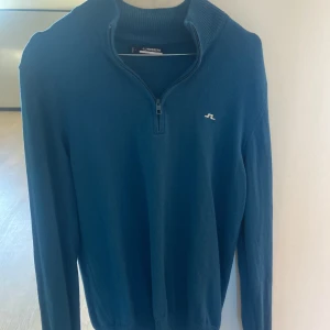 Blå tröja med dragkedja från J.Lindeberg - Snygg blå tröja från J.Lindeberg med halv dragkedja och ribbad krage. Denna tröja är riktigt trändig. Nu pris ligger på 1600 kr. Vårt pris 650kr!!! Priset kan diskuteras😁