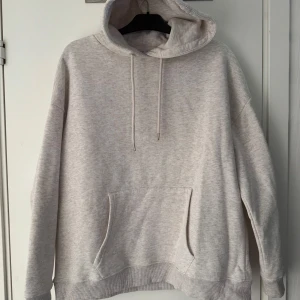 Beige oversized hoodie - Säljer en mysig beige oversized hoodie med känguruficka och justerbar huva. Perfekt för avslappnade dagar. Passar bra till jeans eller mjukisbyxor. Från NLY trend, använd en gång. Strl S💕