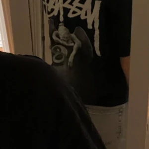 Svart t-shirt från Stüssy - Snygg svart t-shirt från Stüssy med tryck på både fram- och baksidan, säljs då den inte används längre! Finns någon fläck på framsidan 