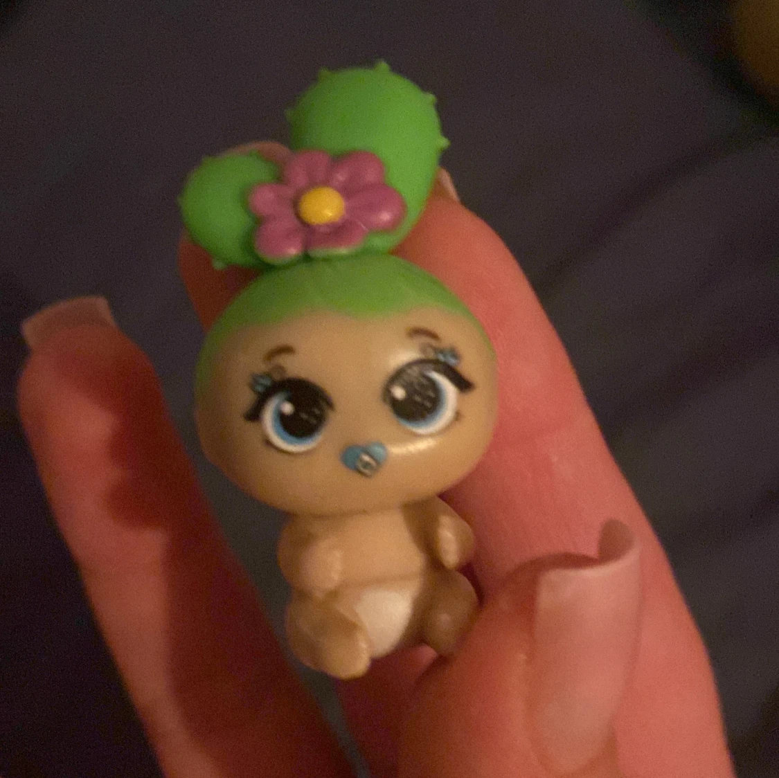 En liten docka med kaktus hår 