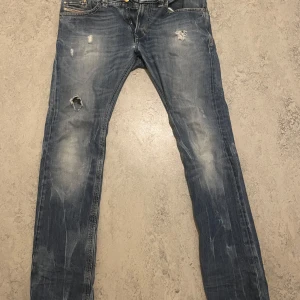 Blå slitna jeans diesel  - Säljer ett par blåa diesel industri jeans med slitningar och hål pga att dom är för tajta för mig och lite för långa. De är i ett jättebra skick med inga defekter. Pris går självklart att diskutera. Kontakta mig för fler frågor👋🙌