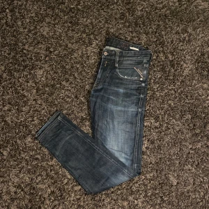 Replay jeans Anbass  - Snygga mörkblå skinny jeans från Replay. Modellen är Anbass och är perfekta för en stilren look med en sliten design. Storlek: W30 L34.