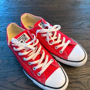 Röda Converse All Star sneakers - Snygga röda Converse All Star sneakers med klassisk design och vita snören. Perfekta för en avslappnad stil. Skorna har en vit tåhätta och en bekväm sula. Använda endast 2ggr. 