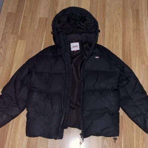 Svart pufferjacka från Tommy Hilfiger - Säljer en svart pufferjacka från Tommy Hilfiger i bra skick, perfekt för vintern 