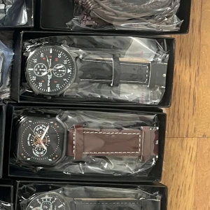 Samling av herrklockor i olika stilar - Säljer en samling av herrklockor i olika stilar och färger. Det finns klockor med svarta, bruna och guldiga armband. Urskivorna är detaljerade med flera visare och kronografer. Perfekt för både vardag och fest. Alla klockor är i nytt skick och kommer i sina originalförpackningar.