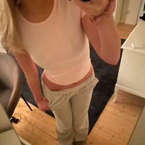 Ljusrosa ärmlös topp - Säljer en superfin ljusrosa ärmlös topp som är perfekt till alla tillfällen. Den är croppad och har en tight passform som framhäver figuren. Toppen är gjord i ett mjukt och bekvämt material, perfekt för både vardag och festliga tillfällen.