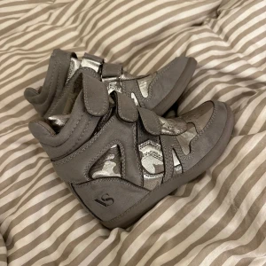 Isabel marant LIKNANDE skor - Isabel marant LIKNANDE skor. Aldrig använda utomhus, endast gått runt med dem inomhus. Ena kardborrebandet är liiite trådigt, se bild 4. Annars inga defekter. Gråa och silvriga. Strl 36.