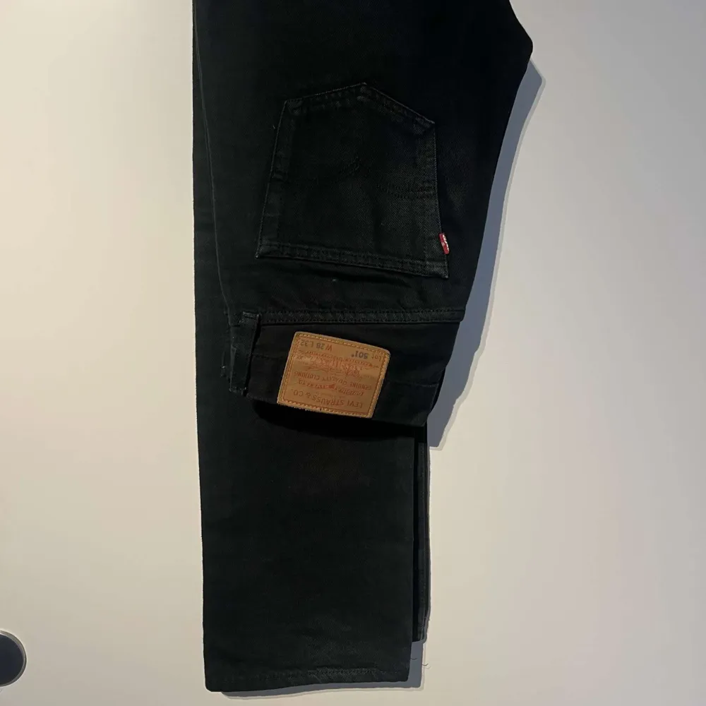 Säljer ett par svarta Levi's 501 jeans i mycket bra skick. De är klassiska och stilrena, perfekta för både vardag och fest. Jeansen har en rak passform och är tillverkade i slitstarkt denim. Passar perfekt till en avslappnad eller uppklädd stil.. Jeans & Byxor.