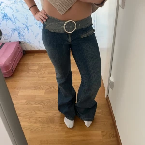 Blå bootcut jeans med bälte - Säljer ett par snygga blå bootcut jeans i bra skick. De är lågmidjade och har ett snyggt bälte runt midjan, vilket gör stt midjan också kan justeras. Så fina men kommer tyvärr inte till använding☺️