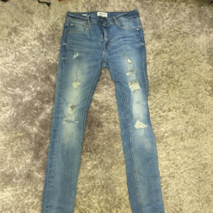 Jack and Jones jeans - Jag säljer nu mina Jack and Jones jeans som är i bra skick, dom är W30 och L28, det är modellen skinny Liam. Jeansen har några slitningar och hål som ni kan se. Skriv om ni har frågor!