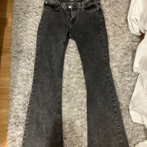 Svarta, grå bootcut jeans  - Säljer ett par svarta, grå bootcut jeans från Gina tricot i storlek 38. Köpte förra året men har en massa andra jeans så de kommer inte till användning. Man ser inte tydligt på bilderna men nere vid jeansen så ser man att de är använda. Köpta för 400-500, kommer inte ihåg exakta pris, och säljer för 200. 