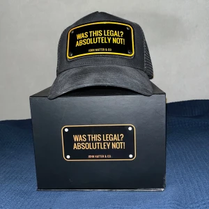 Svart keps från John Hatter & Co - Snygg svart keps med texten 'Was this legal? Absolutely not!' i orange framtill(blev gult med blixt). Kepsen har en klassisk design med justerbar baksida och mesh för ventilation. Perfekt för en avslappnad stil eller som en rolig accessoar. Kommer i en stilren förpackning. Pris går o diskutera vid snabb affär