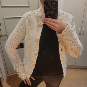 Massimo Dutti kofta - Säljer en superfin vit stickad kofta med flätmönster och dekorativa bollar längs ärmarna💕 Den har långa ärmar och knäpps med knappar framtill. Perfekt för kyliga höst- och vinterdagar. I ull så riktig varm!💕