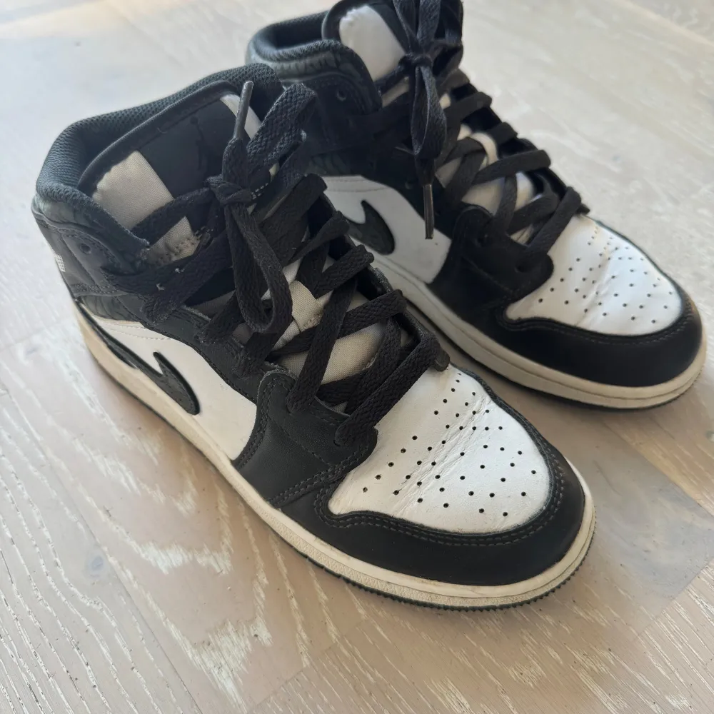 Air Jordan i svart/vitt med mörkgröna spräckliga detaljer. Inköpta på Footlocker MOS vintern 2023.. Skor.