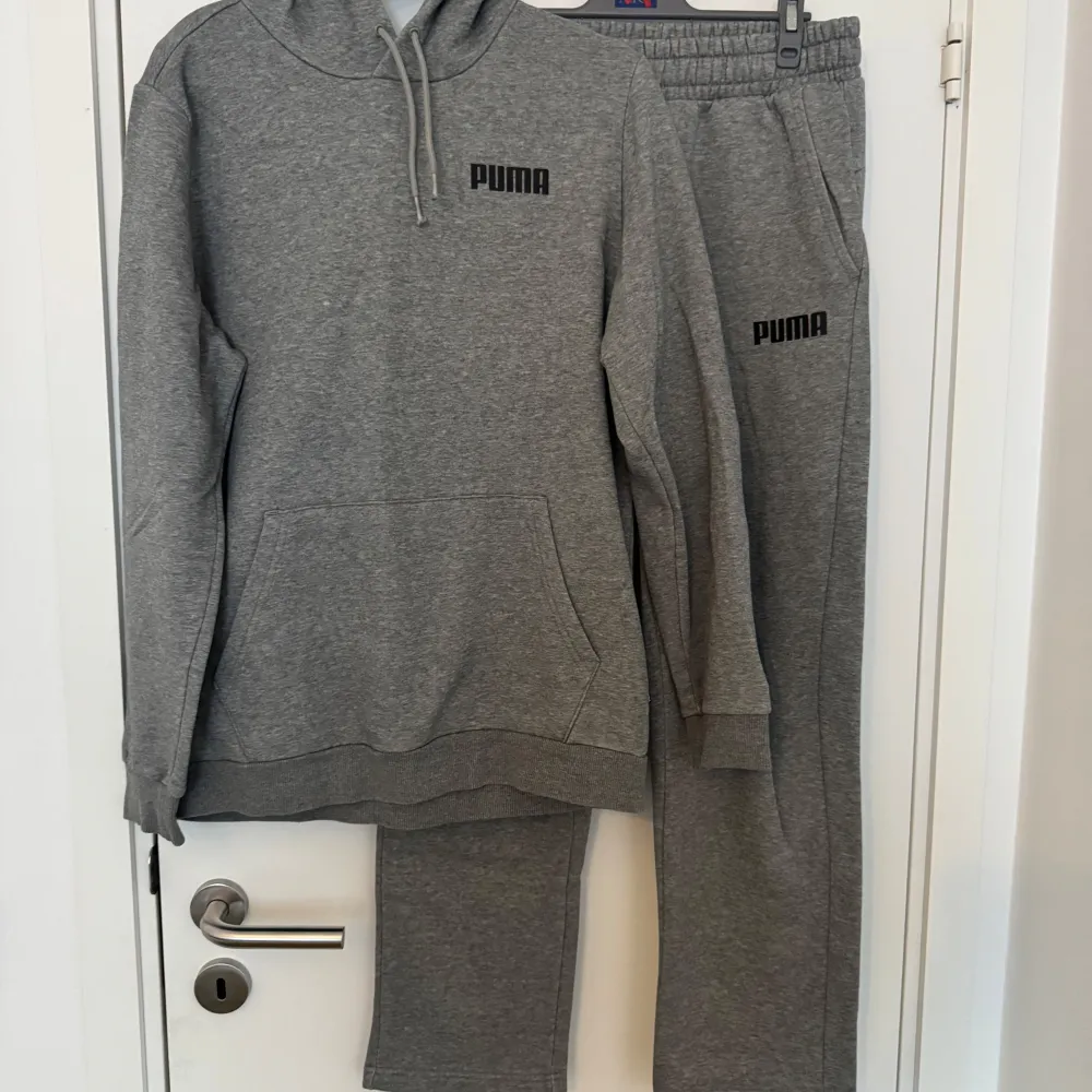 Säljer en grå hoodie och sweatpants från Puma i mycket bra skick. Den är perfekt för både träning och chill med sin mjuka bomullsmix och känguruficka. Hoodien har en justerbar dragsko i huvan och en diskret Puma-logga på bröstet. Passar perfekt till höst och vår!. Tröjor & Koftor.