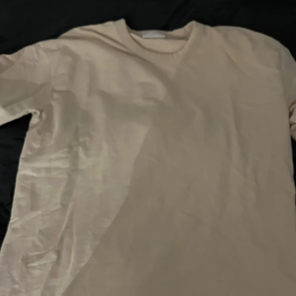 Säljer en stilren beige t-shirt från These Glory Days i storlek L. Perfekt för en avslappnad look, gjord i mjukt material som känns skönt mot huden. Passar bra till både vardag och fest. Ett måste i garderoben! 🌟. T-shirts.