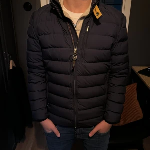 Mörkblå pufferjacka från Parajumpers - Säljer en snygg mörkblå pufferjacka från Parajumpers i superlätt material. Jackan har en dragkedja framtill och är perfekt för höst och vår. Den är i mycket bra skick och har en normal passform. Perfekt för dig som vill hålla stilen när det är kyligt ute! 💙